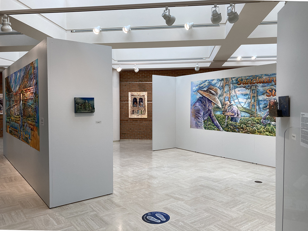 entrance to installation show a small relief, watercolor painting, billboard and small relief painting (l-r)